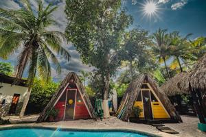 a resort with a pool and two playhouses at Playa Grande Surf Camp in Playa Grande