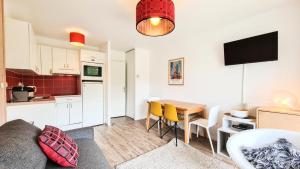 ein Wohnzimmer mit einer Küche und einem Tisch mit einem Sofa in der Unterkunft Résidence Les Pleiades - 2 Pièces pour 6 Personnes 794 in Magland