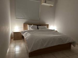 een slaapkamer met een bed en een nachtkastje met 2 lampen bij شقة فاخرة بدخول ذاتي/غرفة و صالة و مطبخ و حمام in Riyad