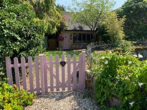 a white picket fence in front of a house at Piglet Cottage in Pebworth