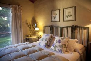 una camera da letto con letto, cuscini e finestra di La Caledonia Cabañas Boutique a Sierra de la Ventana
