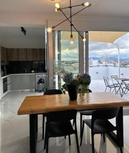 Il comprend une cuisine et une salle à manger avec une table et des chaises en bois. dans l'établissement Luxury Penthouse-Panoramic View!, à Nicosie