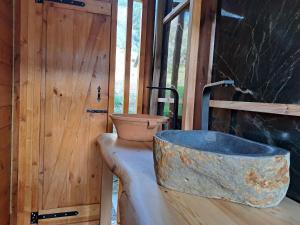 a stone tub sitting next to a wooden door at Wooden House at the Mountain-private in Paránimfoi