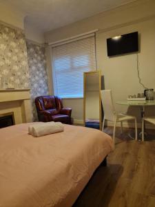 1 dormitorio con 1 cama, mesa y sillas en ArklesFCLiverpool, en Liverpool