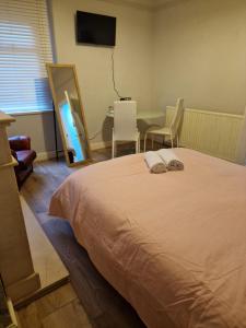 a bedroom with a bed and a table with chairs at ArklesFCLiverpool in Liverpool