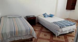 a bedroom with a bed and a night stand at Casa de Huespedes Milena in Puerto Baquerizo Moreno