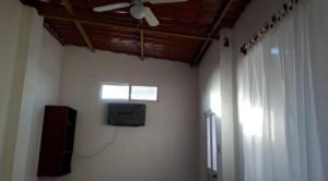 a room with a ceiling fan and a tv on a wall at Casa de Huespedes Milena in Puerto Baquerizo Moreno