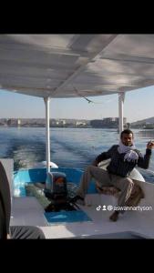 un homme assis à l'arrière d'un bateau sur l'eau dans l'établissement El manzel, à Assouan