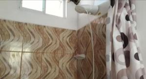 uma casa de banho com uma cortina de chuveiro e um piso de madeira em Casa de Huespedes Milena em Puerto Baquerizo Moreno