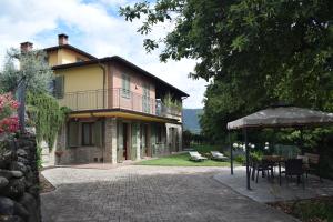 ein Haus mit einem Tisch und einem Sonnenschirm davor in der Unterkunft Podere Saranna in Pescia