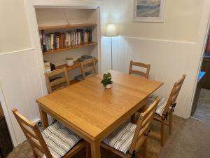 a dining room table with chairs and a book shelf at 4 bedroom townhouse Kirkcudbright in Kirkcudbright