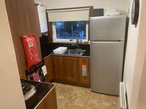 a kitchen with a refrigerator and a sink at 4 bedroom townhouse Kirkcudbright in Kirkcudbright
