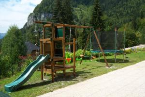 einen Spielplatz mit Rutsche und Schaukeln in der Unterkunft Résidence Le Fontenay in Plateau dʼAssy