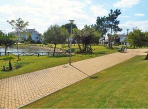 um parque com um caminho ao lado de uma massa de água em Luxury Hacienda Golf Islantilla em Islantilla