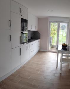 a kitchen with white cabinets and a table and a window at CASA MIRANDA in Ourense