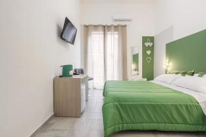 una camera con due letti verdi e una televisione di Case Billeci Casa Verde a Palermo