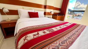 a bedroom with a large bed with a red pillow at La Mansion Casa Hotel in Andahuaylas
