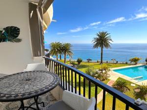 balcón con mesa y vistas al océano en Acapulco Playa 302 Apartments Casasol en Nerja