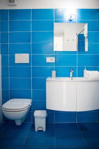 YourHome - H2O Marina Apt Sea View في بوسيتانو: حمام من البلاط الأزرق مع مرحاض ومغسلة