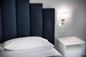 YourHome - H2O Marina Apt Sea View في بوسيتانو: غرفة نوم بها اللوح الأمامي الأزرق وسرير أبيض