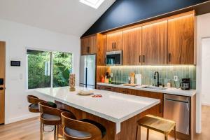 a kitchen with wooden cabinets and a counter with chairs at Private Gated 3 BD - 3 BR Modern Home in Los Angeles