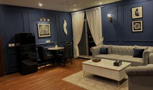 a living room with blue walls and a couch and a table at Royal Reside in Rawalpindi