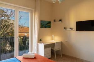 a bedroom with a desk and a window and a bed at L'Arancio house- Perfect for families and groups in Sorrento