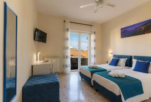 a hotel room with two beds and a balcony at L'Arancio house- Perfect for families and groups in Sorrento