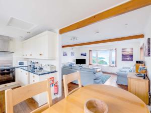 a kitchen and living room with a table at Shilling Stones in Port Isaac
