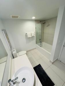 a white bathroom with a toilet and a shower at Lovely 1 Bedroom & 1 Bath Kitchen Balcony 18 Floor in Hallandale Beach
