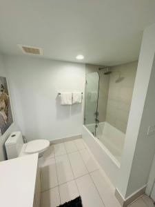 uma casa de banho branca com um chuveiro e um WC. em Lovely 1 Bedroom & 1 Bath Kitchen Balcony 18 Floor em Hallandale Beach