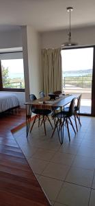 a dining room with a table and chairs and a large window at Solar de Roca in Embalse