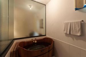 a bathroom with a wooden tub with a mirror at Resort Fazenda 3 Pinheiros in Engenheiro Passos