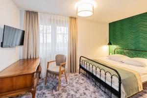 a hotel room with a bed and a desk at Hotel Zum Pfeiffer in Radebeul