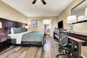 a hotel room with a bed and a desk and a computer at Scottish Fairway Inn in Monterey