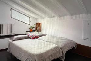 a bedroom with a large bed with a window at Casa Rina in Cannobio