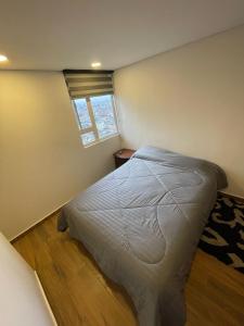 a bedroom with a bed in a room with a window at Apto excelente Ubicación Bogotá in Bogotá