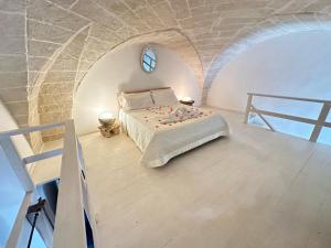 1 dormitorio con 1 cama en una pared de piedra en LE DIMORE CENTRO en Gallipoli