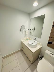 y baño con lavabo, espejo y aseo. en Lovely 2Bed 1Bath Condo With Private Balcony 18th Floor, en Hallandale Beach