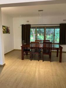 uma sala de jantar com uma mesa de madeira e cadeiras em The ranch apartments, en-suite rooms em Lusaka
