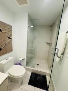 a white bathroom with a shower and a toilet at Lovely 2Bed 1Bath Condo With Private Balcony 18th Floor in Hallandale Beach