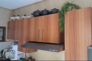 uma cozinha com armários de madeira com panelas e frigideiras em Refúgio Aconchegante e Espaçoso em Araguaína