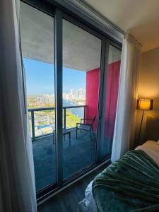 1 dormitorio con vistas a un balcón con cama en Lovely 2Bed 1Bath Condo With Private Balcony 18th Floor, en Hallandale Beach