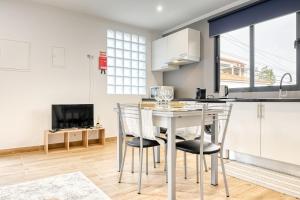 uma cozinha e sala de jantar com mesa e cadeiras em Casa dos Anjos, a Home in Madeira no Faial