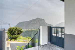 uma casa com um portão com vista para uma montanha em Casa dos Anjos, a Home in Madeira no Faial