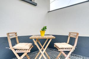 Dos sillas y una mesa con una planta. en Casa dos Anjos, a Home in Madeira, en Faial
