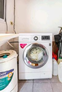 a white washing machine sitting next to a trash can at Oasis Munro in Munro