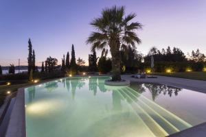 a swimming pool with a palm tree in the middle at Porto Heli - Heaven on Earth Villa in Ermioni