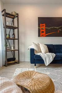 a blue couch in a living room with a painting at Revelstoke Alpine Retreat - RARE One-Bedroom Condo in Revelstoke