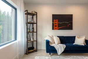 sala de estar con sofá azul y ventana en Revelstoke Alpine Retreat - RARE One-Bedroom Condo, en Revelstoke